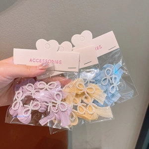 Three elegant tulle hair clips with pearls and ribbons in purple, yellow, and blue