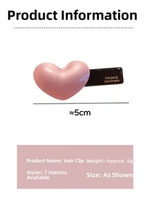 Detail view of pearlescent pink acetate heart hair clip with handmade gold lettering