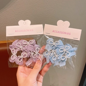 Detail of baby pearl ribbon bow hair clips set in purple and light blue fabric textures
