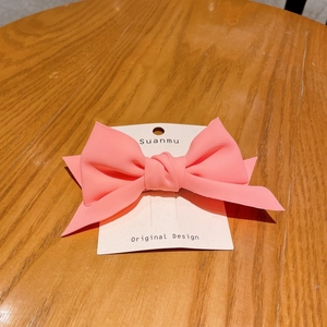 Detailed view of a sweet 3D pink fabric bow hairclip on a Suanmu display card