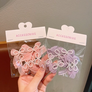 Detail of pink and purple pearl ribbon bow hair clips set in clear packaging