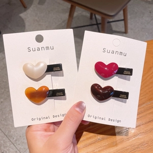 Chic heart-shaped acetate hair clips set in ivory, amber, wine red and coffee finishes