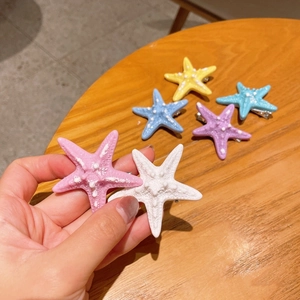 Dettaglio di fermagli per capelli a stella marina colorati con trama realistica