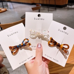 Barrettes à cheveux élégantes en acétate avec nœud et strass colorés sur fond écaille
