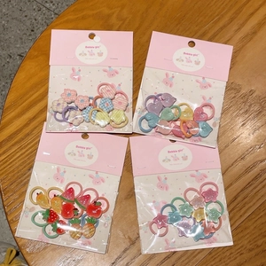 Vista dettagliata di quattro confezioni di elastici per capelli colorati con ciondoli a stella