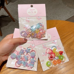 Dettaglio di elastici per capelli colorati per bambini con ciondoli in resina e frutta
