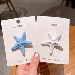 Vista dettagliata di fermagli per capelli a stella marina blu e bianchi con texture bionica