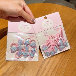 Dettaglio di fermagli per capelli con creature marine glitterate ed elastici a stella