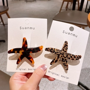 Gros plan de barrettes étoile de mer en acétate avec motifs tortue et léopard chic