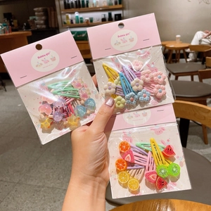 Dettaglio del set di fermagli per capelli per bambini con ciondoli a stella, fiori e frutta