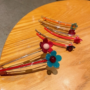 Set di fermagli per capelli con fiori in resina su uno sfondo di tavolo in legno rustico