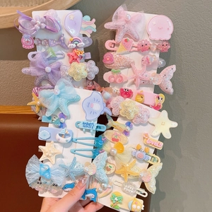 Detail of glittery mermaid tail and starfish hair clips with sequins and soft tulle mesh