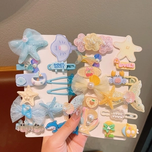 Detailed view of ocean themed hair clips with sequins and mesh on a display card