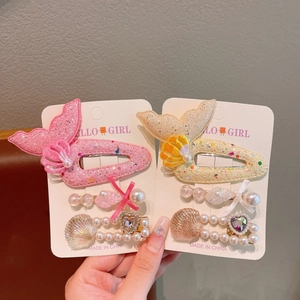 Detail of pink and beige mermaid hair clips set with sequins and artificial pearls