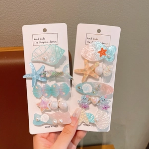 Macro detail of ocean-themed hair clip set with resin starfish and shell charms