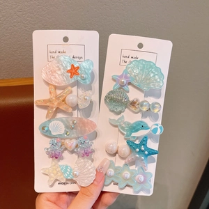 Close-up of ocean-themed resin hair clips featuring sea creatures with pearl accents
