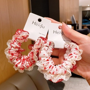 Detail of red gingham and polka dot hair ties with white lace trim on card packaging