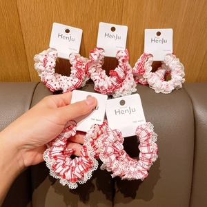 Detail of five red and white scrunchies with polka dots, lace trim and patterns
