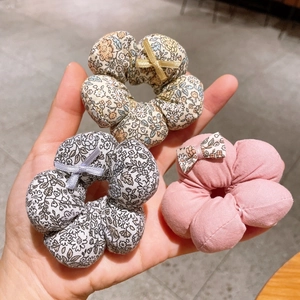 Detail of floral fabric hair scrunchies with bow tie accents in three colors