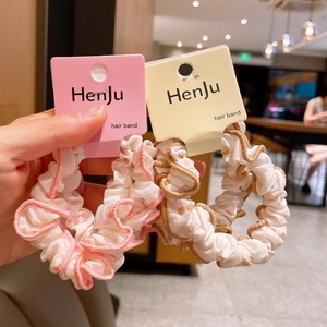Detail shot of floral chiffon hair scrunchies with pink and brown ruffled edges