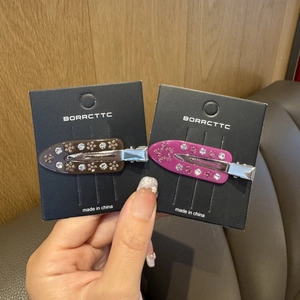 Detail of glitter marble acetate hair clips with crystal inlay on a display card