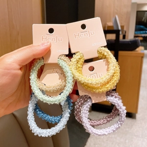 Detailed macro view of pastel knitted plush hair scrunchies with wavy soft texture