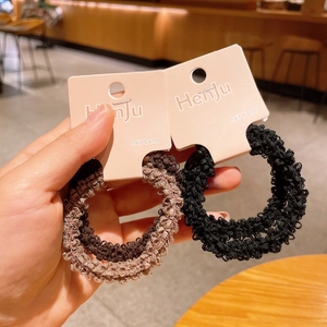 Close-up of soft black and brown lace knitted hair scrunchies set with product tags