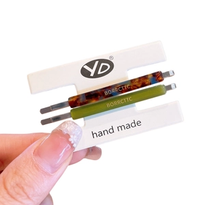 Retro acetate hair clips set with tortoiseshell and green patterns on display card