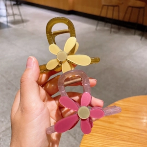 Détail de pinces à cheveux florales vert olive et violettes avec motifs tournesols