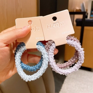 Detailed view of high-elasticity woven hair bands in pastel blue and pink colors