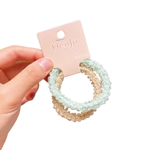 Three-piece elastic plush hair rings set in pastel green and beige woven fabric