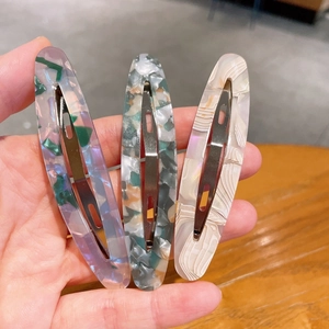 Vue détaillée de trois barrettes en acétate avec motifs marbrés et floraux