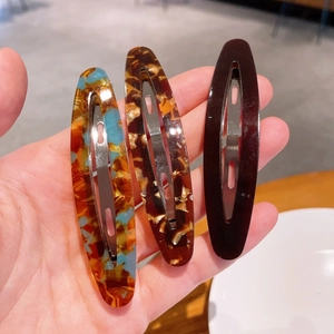 Détail de trois grandes barrettes en acétate avec motifs écaille et marbré