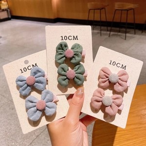 Three pairs of colorful cotton bow hair clips with button details on 10cm cards