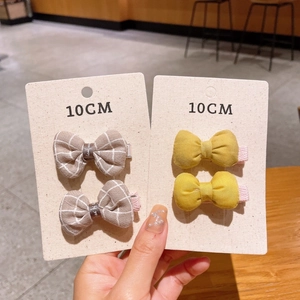 Close-up of 10cm fabric bow hair clips in grey plaid and bright yellow sets