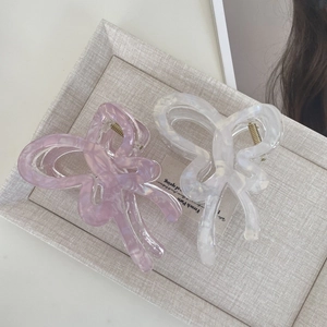 Detailed close-up of butterfly claw hair clips in marbled purple and cream acetate