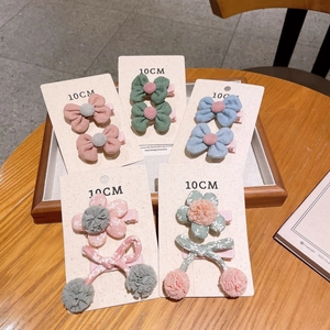 Detail of five handmade cotton bow and floral hair clips on a 10cm display card