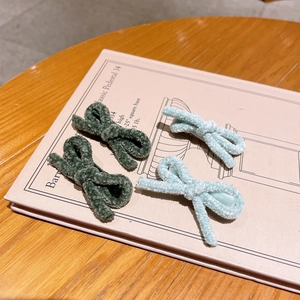 Detailed close-up of velvet bow hair clips in navy blue and light blue on a book