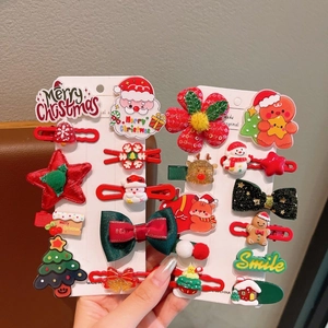 Detalle de un set de 10 pinzas para el pelo navideñas con Papá Noel, muñeco de nieve y lazos