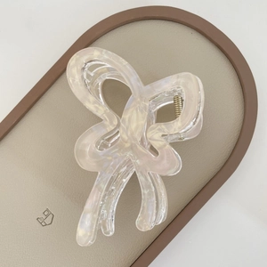Detailed macro view of pearlescent jelly butterfly hair claw clip with gold metal spring