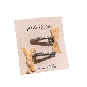Lot de deux barrettes à cheveux pailletées argent avec nœuds en velours beige