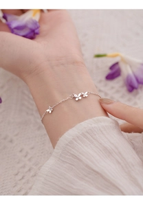 Gros plan d'un bracelet papillon argenté avec pierres étincelantes sur un poignet féminin