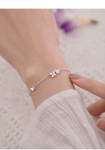 Vue détaillée du bracelet papillon en argent avec pierre de zircon sur fond de dentelle