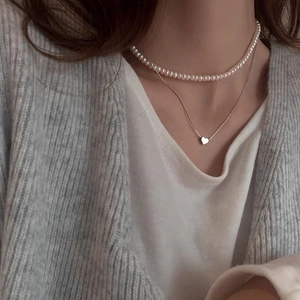 Double-layered necklace with freshwater pearls and a minimalist silver heart pendant for women
