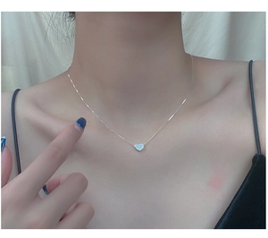 Detailed view of silver minimalist heart pendant necklace on a delicate chain