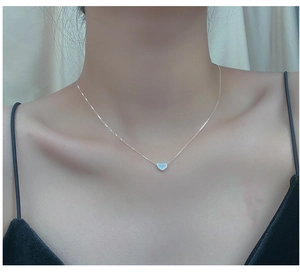Minimalist silver heart pendant necklace on model with elegant box chain detail