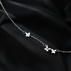 Collier papillon argenté élégant avec zircone scintillante sur fond de tissu noir