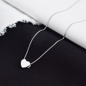 Minimalist silver heart pendant necklace with polished finish on a box chain for women
