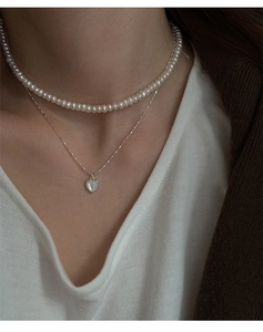 Dettaglio della collana a cuore in argento S925 con conchiglia e girocollo di perle