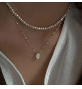 Primo piano della collana doppia in argento s925 con perle bianche e pendente a cuore